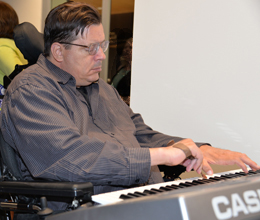 John Kraimer, a ThinkFirst Voice for Injury Prevention, plays the keyboard with the help of a typing stick.
